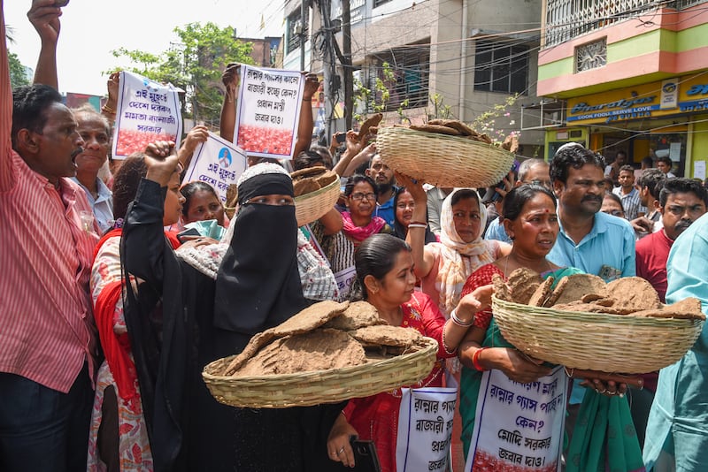 Members of a political party - All India Trinamool Congress - hold cow-dung cakes and posters during a protest over LPG prices. Photograph: Debajyoti Chakraborty/NurPhoto via Getty Images