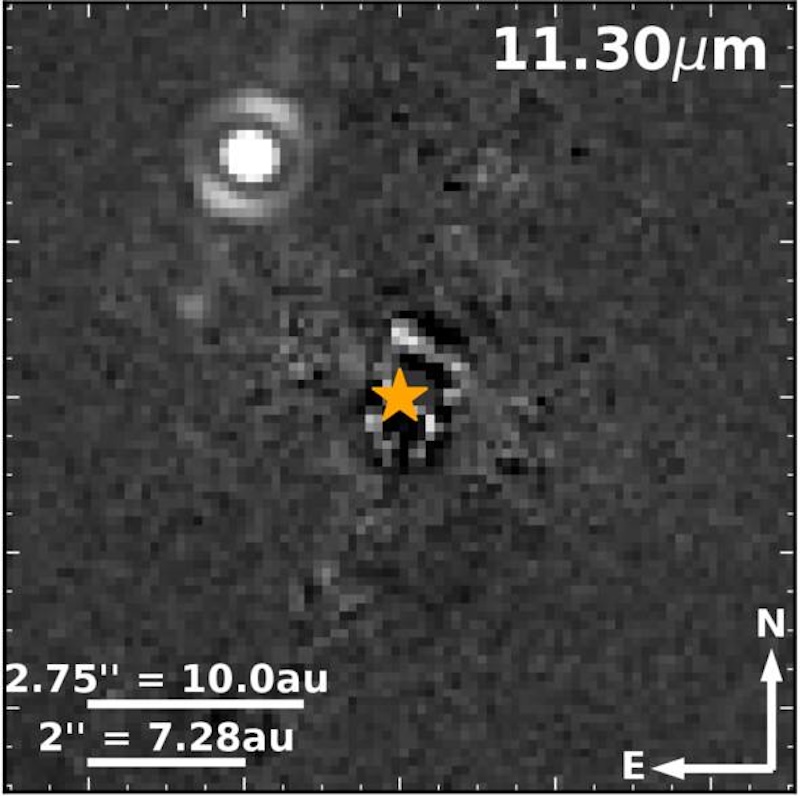 Bright white spot and yellow star on dark, mottled background.