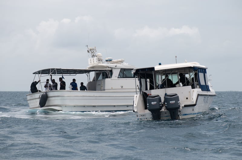 Members of the Maldives marine police search for the missing divers. Photograph: Sophia Nasif/EPA