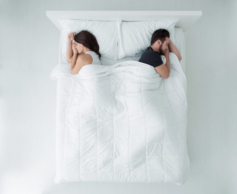Couple sleeping in bed - stock photo