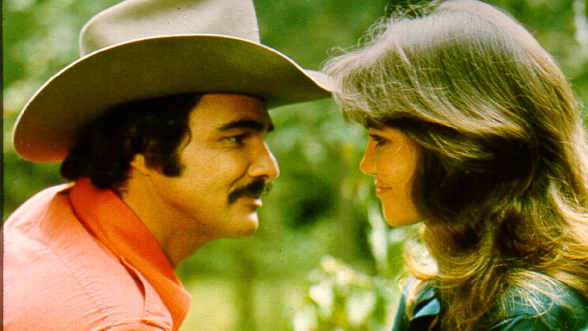 Actors Burt Reynolds and Sally Field standing in a scene from Smokey and the Bandit