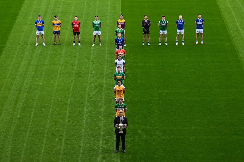 GAA president Jarlath Burns holding the Tailteann Cup, alongside representatives from each of this year's competing counties. Photograph: Sam Barnes/Sportsfile
