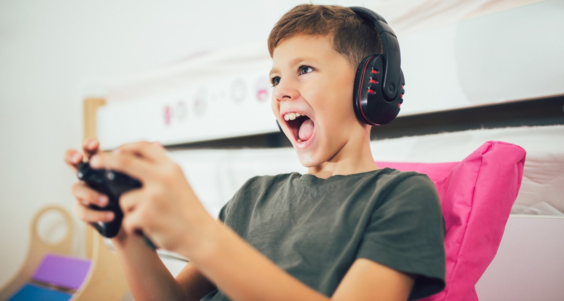 Little boy with gamepad playing video game at home