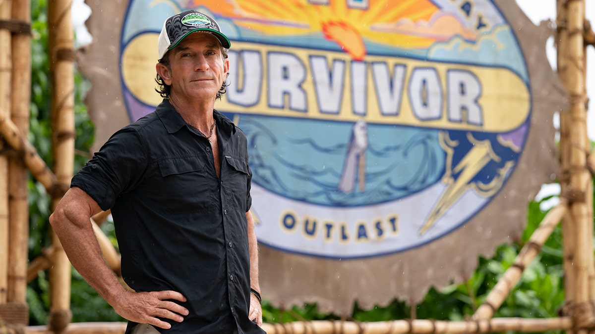 Survivor host Jeff Probst standing against a dark background