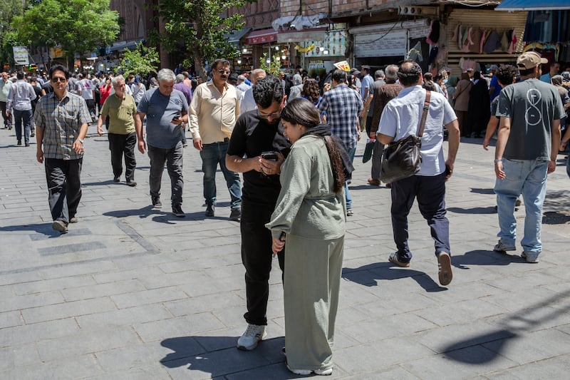 A man and woman check his smartphone in Tehran, Iran. Photograph: Arash Khamooshi/Polaris for The New York Times