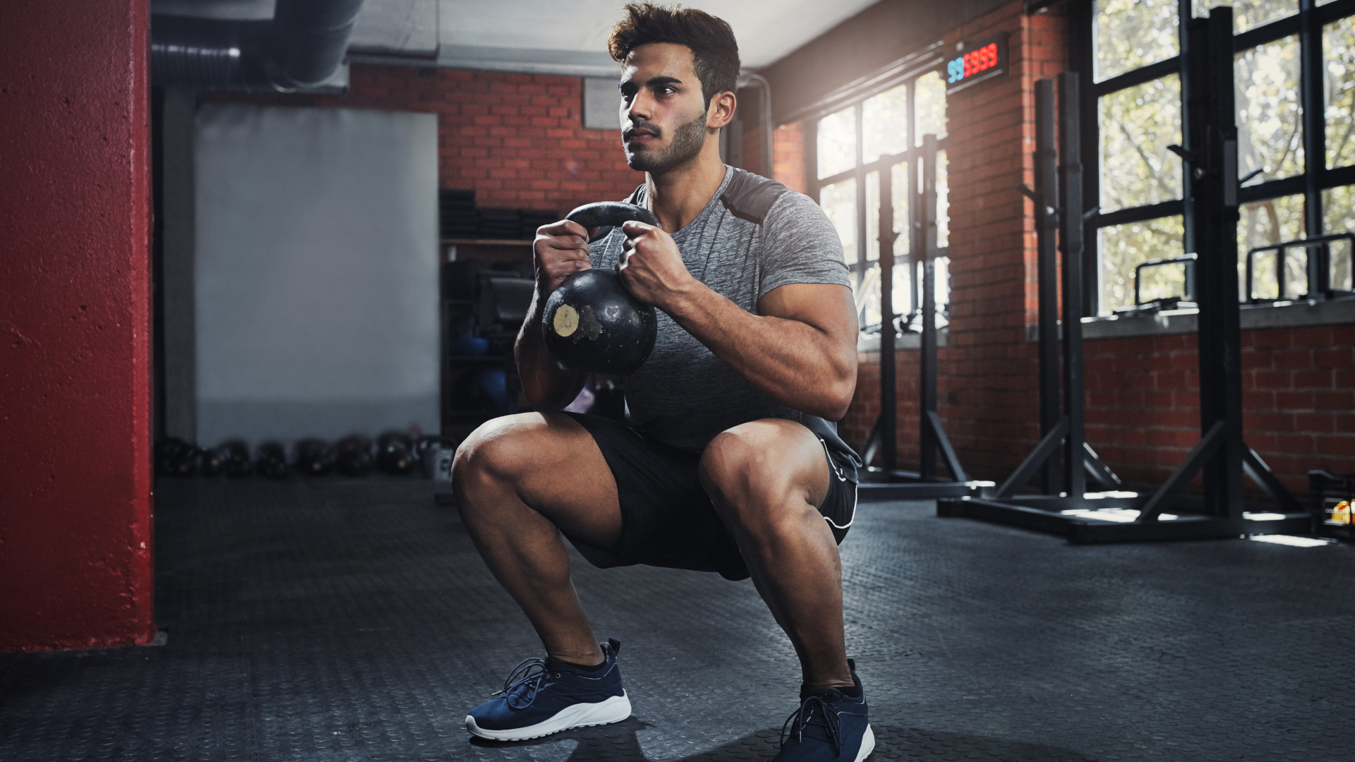 A man performing a goblet squat at the gym