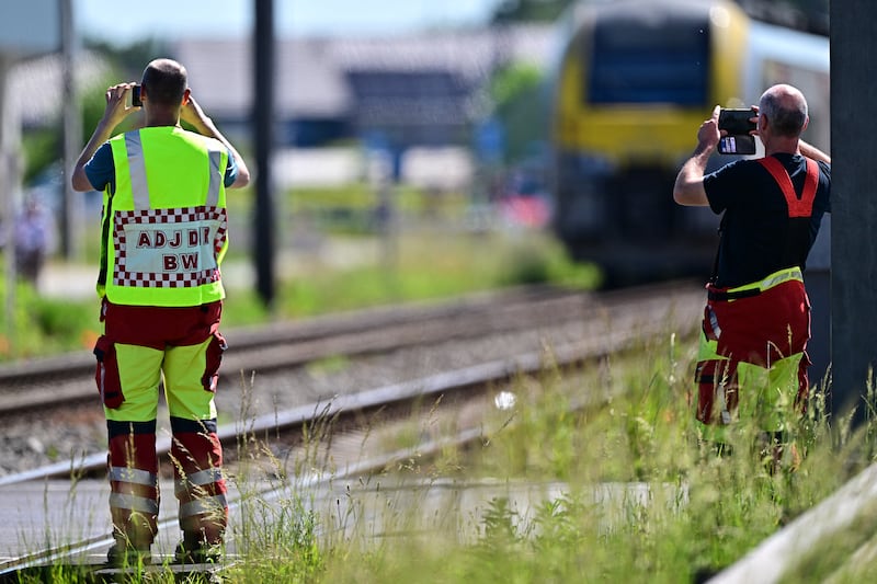 Emergency services take images with their smartphones at the site of crash involving a train and schoolbus. Photograph: Dirk Waem/Belga/AFP/Getty Images
