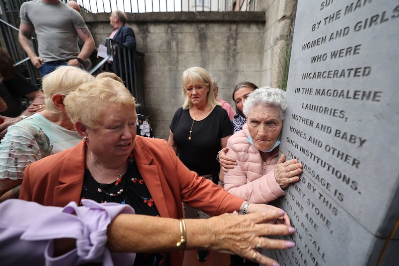Survivors of Magdalene Laundries and other State institutions touch a monument acknowledging victims that was unveiled in 2022 in Dublin. Photograph: Nick Bradshaw/The Irish Times