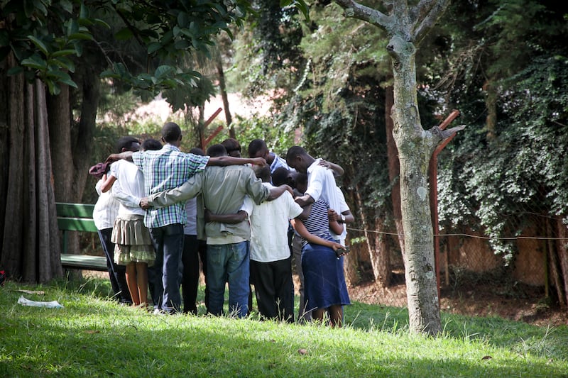 An "artificial family" prays together in Kigali in 2014. For Sally Hayden piece May 2025