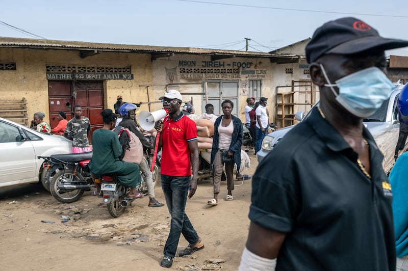 A market official seeks to raise awareness of the Ebola outbreak in Bunia, Democratic Republic of Congo. Photograph: Arlette Bashizi/The New York Times
                      