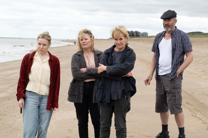 483139,Sherwood - Series 2 Christine Bottomley as Rachel Crossley, Monica Dolan as Ann Branson, Lorraine Ashbourne as Daphne Sparrow and Stephen Dillane as Roy Branson in Sherwood season 2 standing on a beach and looking out with stressed looks on their faces.