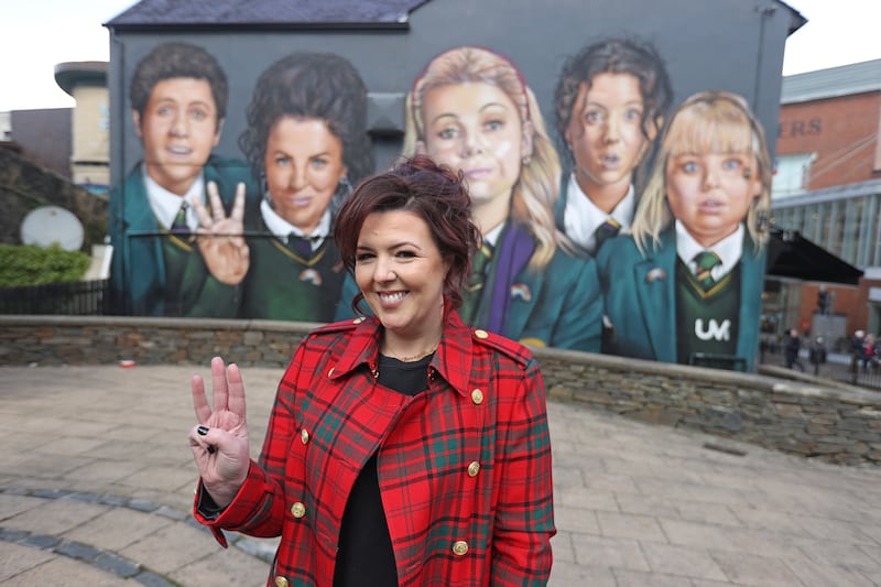 Writer Lisa McGee in front of a Derry Girls mural in Derry. Photograph: Liam McBurney/PA