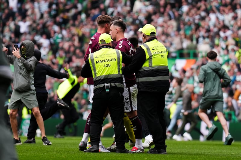 Hearts player Lawrence Shankland is escorted from the pitch by security after Celtic fans invaded the pitch before the end of Saturday's title-deciding match at Celtic Park. Photograph: Andrew Milligan/PA Wire
