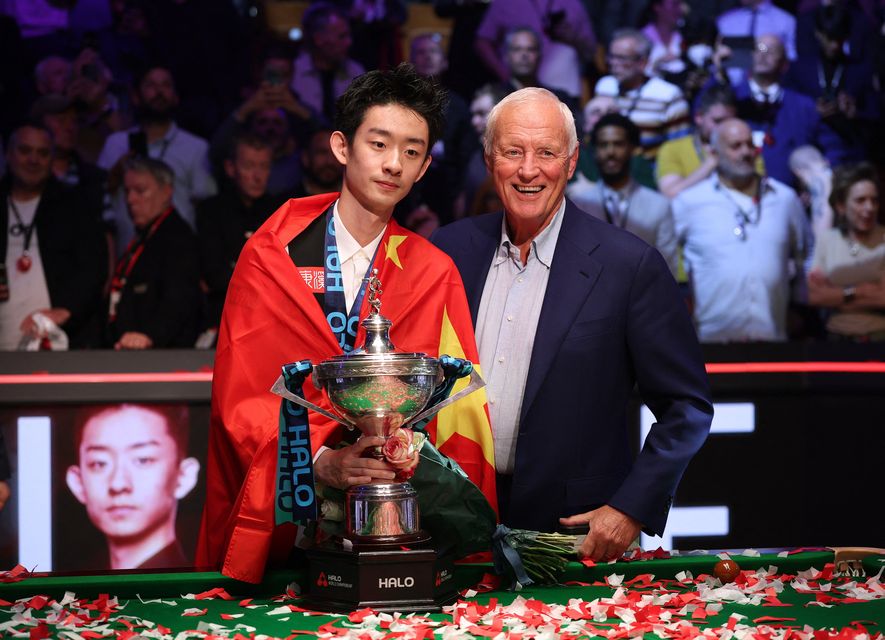 China's Wu Yize poses with the trophy alongisde Matchroom Sport chairman and sports promoter Barry Hearn after winning the World Snooker Championship