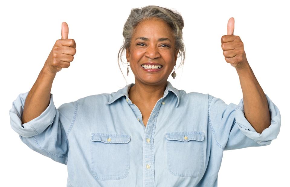Someone is smiling and holding two thumbs up.