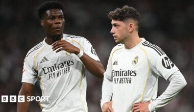 Real Madrid's Aurelien Tchouameni and Federico Valverde stand next to each other in a match, wearing the club's white kit