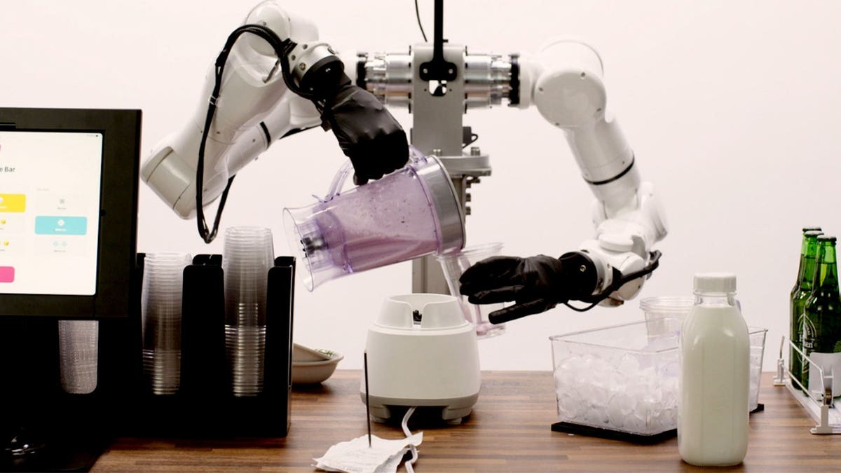 A robot pours a smoothie.