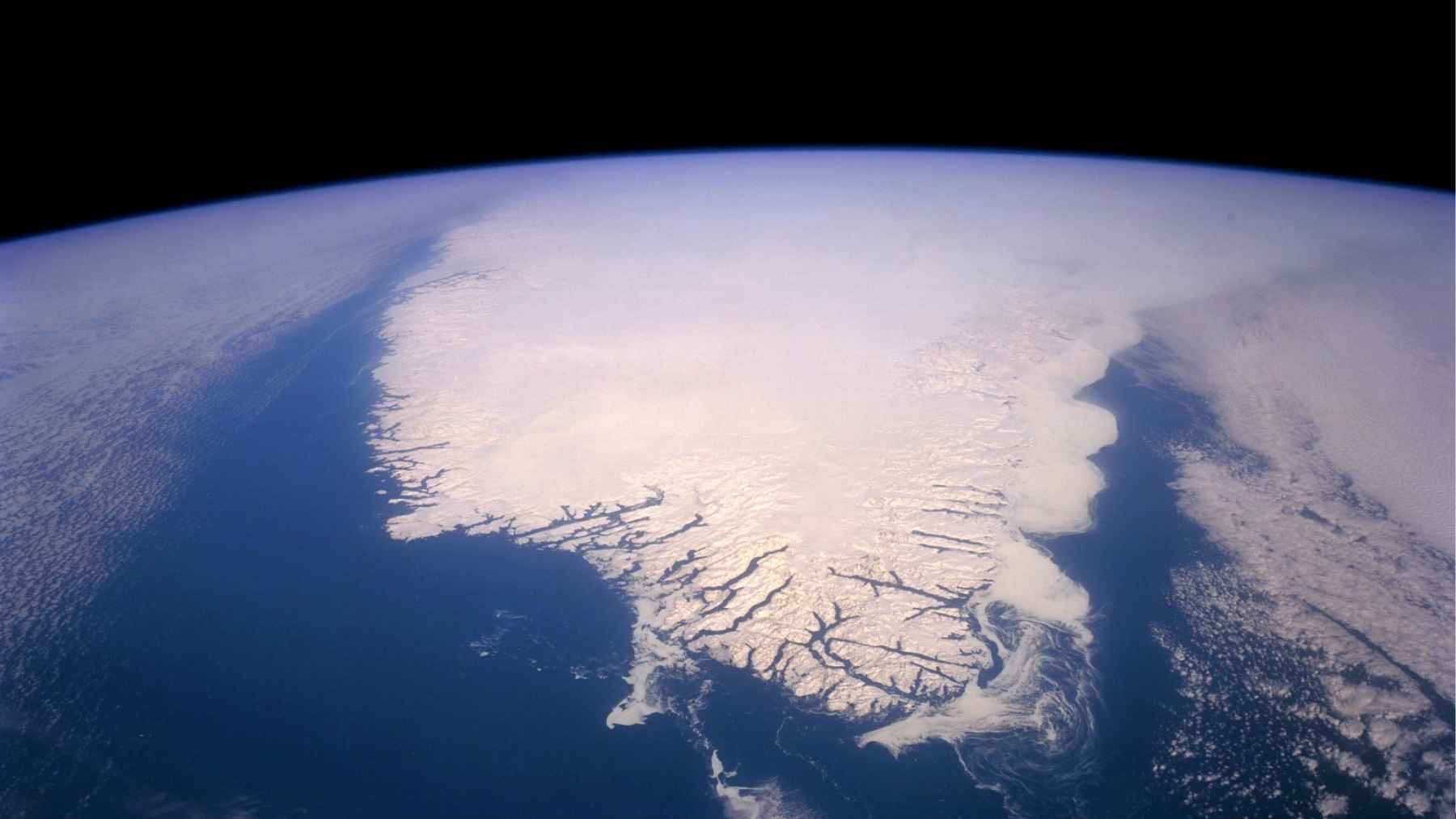 Satellite view of Arctic sea ice and open ocean, showing the polar ice cover from above Earth.