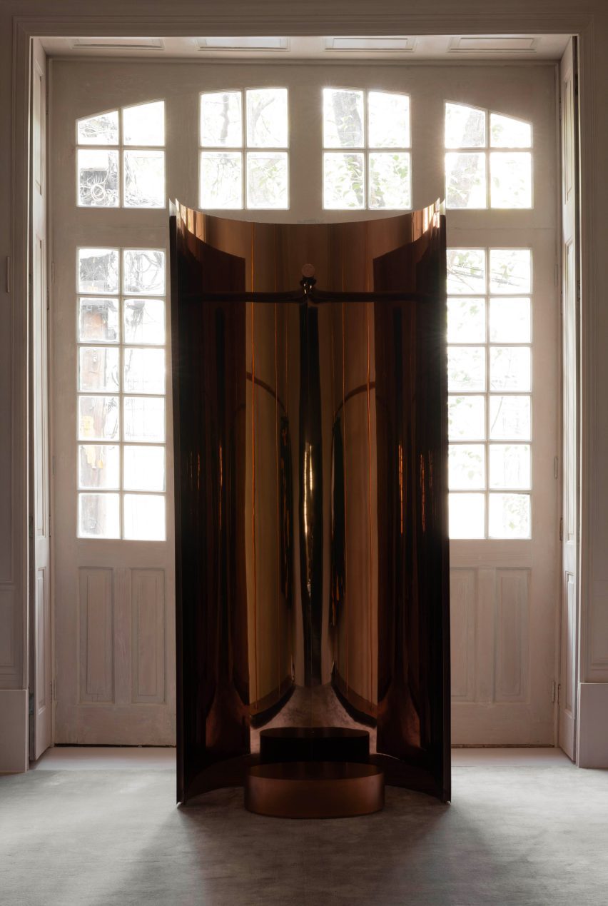 A mirrored concave stand is centred in front of a large window