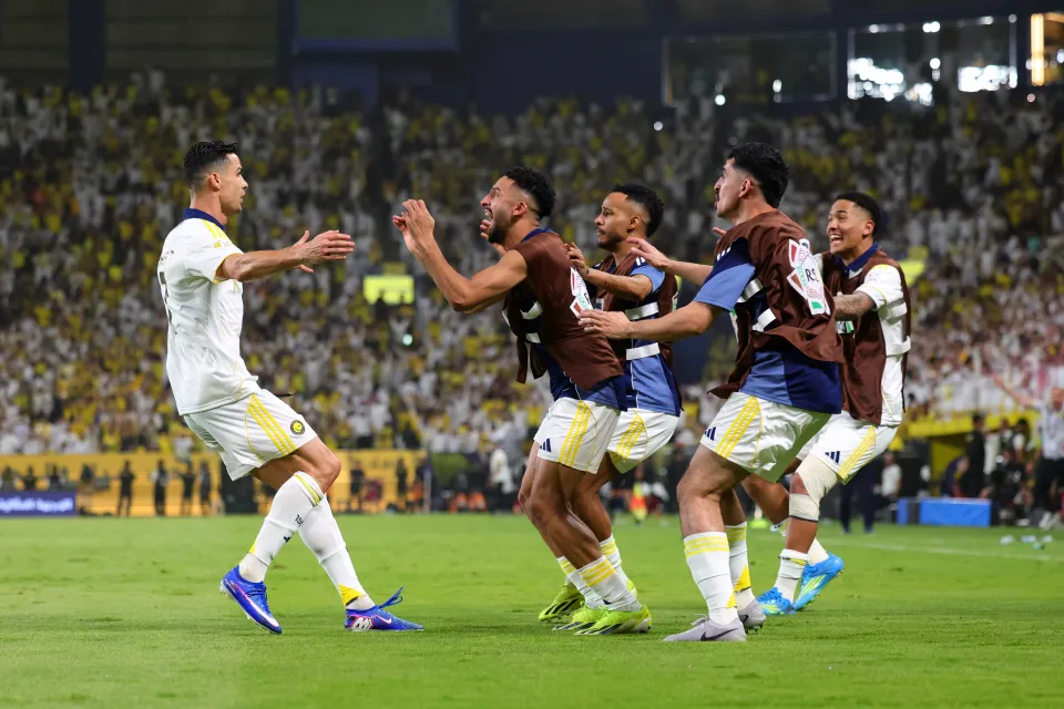 Cristiano Ronaldo of Al Nassr celebrates with teammates after scoring his team's third goal during the Saudi Pro League match between Al Nassr and Damac
