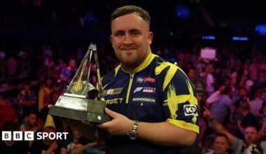 Luke Littler holding the Premier League trophy