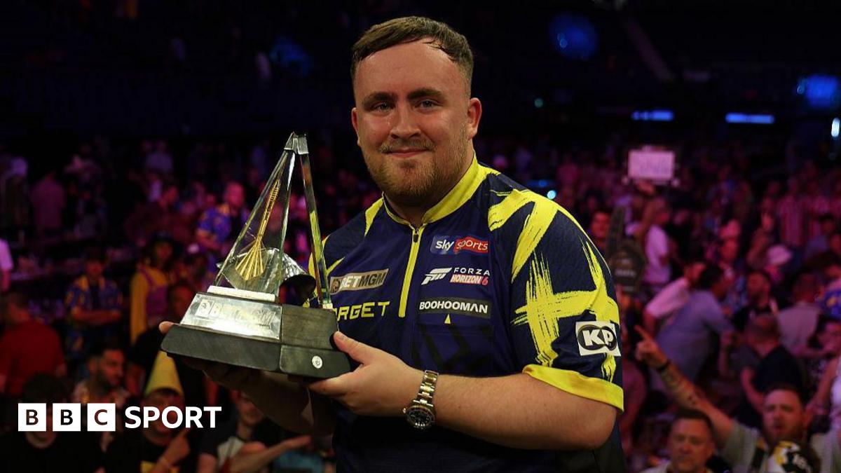 Luke Littler holding the Premier League trophy