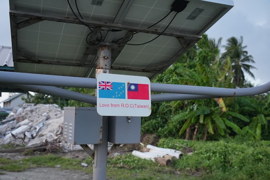 A photo of a metal plate with a Tuvalu and Taiwanese flag side by side reading "Love from Taiwan".