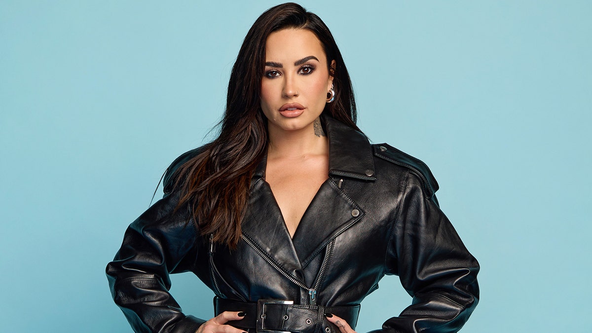 Demi Lovato posing in a black leather jacket at the Rock and Roll Hall of Fame Induction Ceremony in Cleveland
