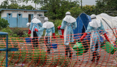Health workers in full protective gear entering an Ebola treatment center in Rwampara, Congo.