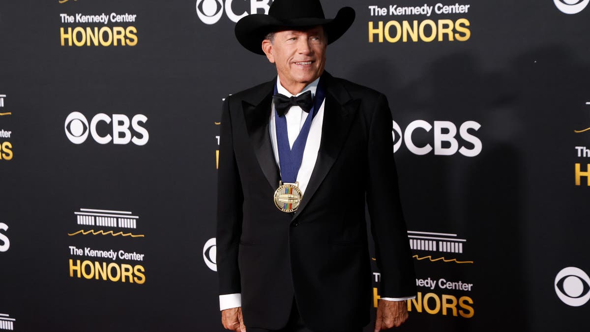 George Strait standing in a dark suit at the Kennedy Center Honors event
