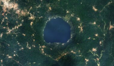 A 2015 satellite photo showing a series of golden tendrils surrounding a round blue lake