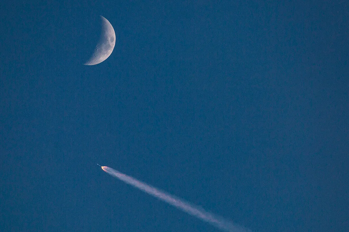 A SpaceX Falcon 9 rocket in the sky with a crescent Moon, 10 July 2024. Credit: George Rose/Getty Images