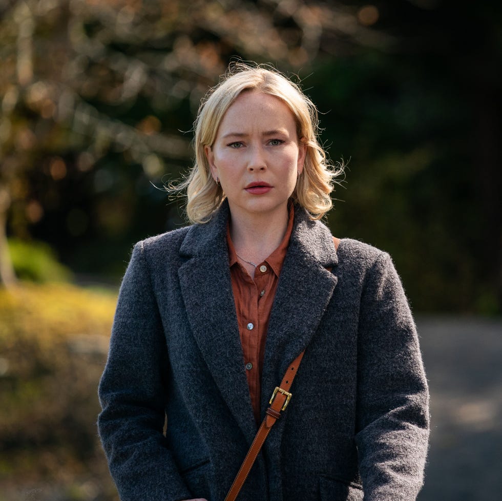 person in a gray coat with a blurred face standing outdoors person in a gray coat with a blurred face standing outdoors