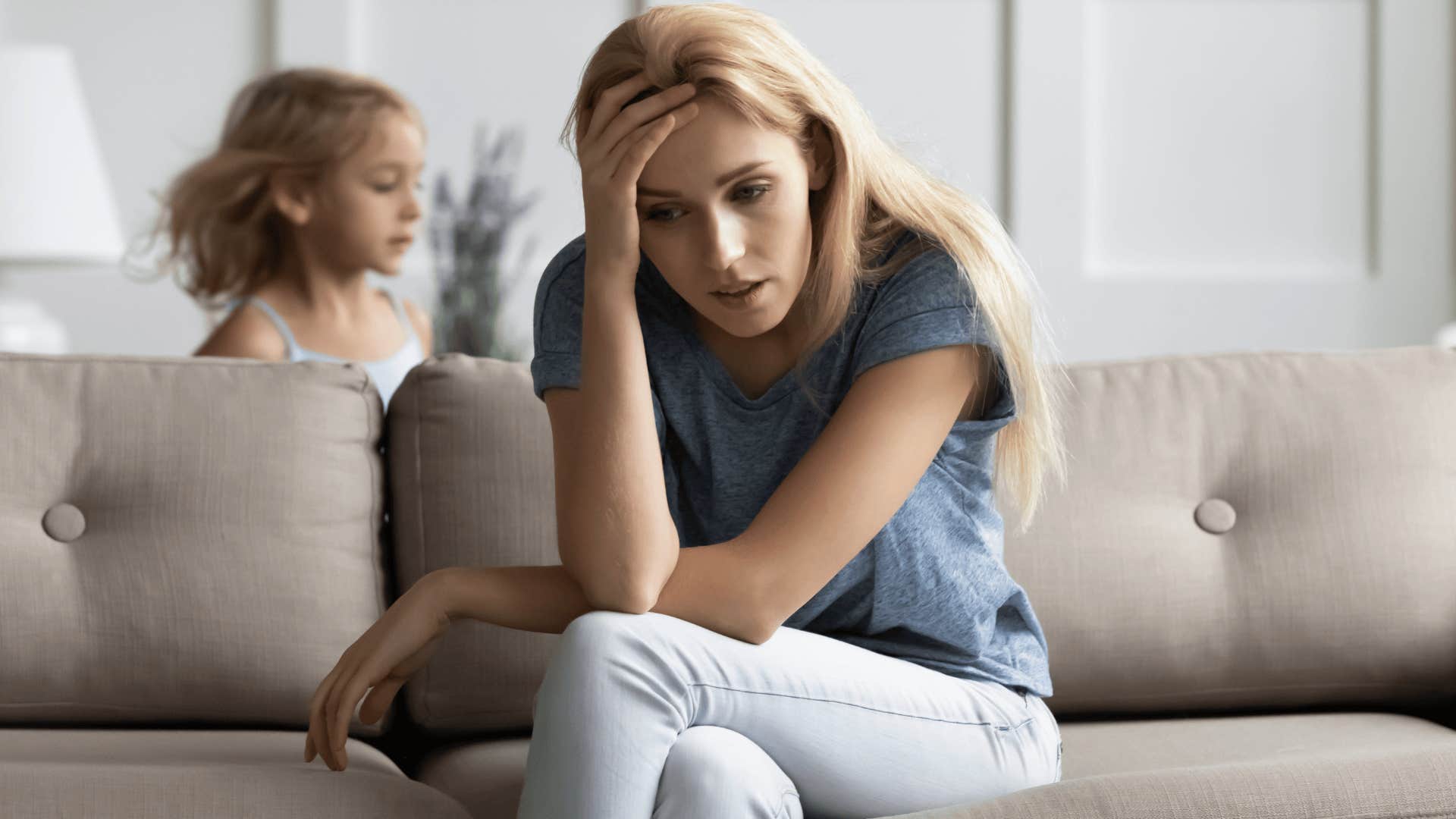 stressed mother who can't afford childcare sitting while kids run around