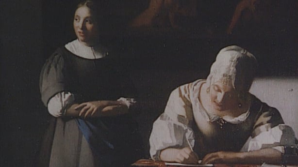 A detail of the Vermeer painting, showing a woman writing a letter at a table while another woman stands behind her