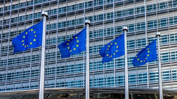 Four European flags fluttering against the Berlaymont building, headquarters of the European Commission in Brussels