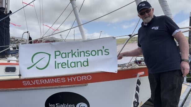 Pat Lawless standing beside his yacht