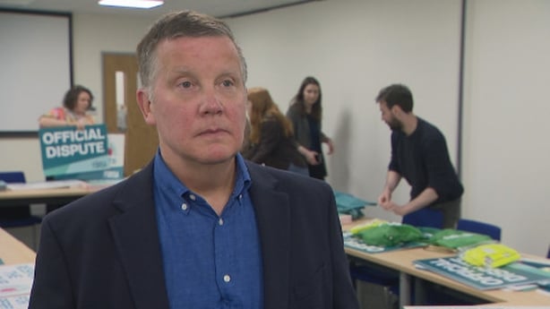 Rob Regan standing in front of tables and colleagues