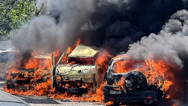 Flames engulf vehicles following an Israeli airstrike that hit a car in Sidon, Lebanon