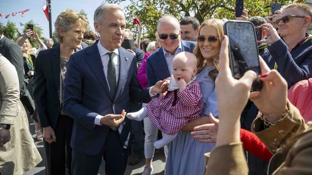 Canadian Prime Minister Mark Carney has a picture taken with Lily Meskil
