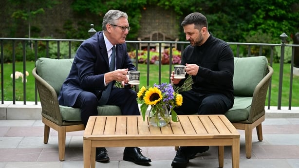 Britain's Prime Minister Keir Starmer (L) and Ukraine's President Volodymyr Zelensky hold mugs as they sit and talk in the garden of 10 Downing Street in central London, on August 14, 2025. Ukrainian President Volodymyr Zelensky was met with ally UK Prime Minister Keir Starmer in London on Thursday