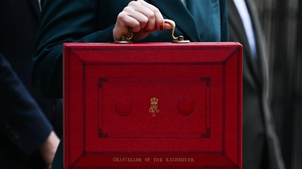 A red despatch box with the British budget in it being held outside 11 Downing Street ahead of it being presented during to the UK parliament in London