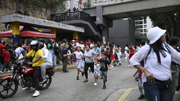 People run into a street following an earthquake in Caracas on June 24, 2026. A magnitude 7.1 earthquake struck Venezuela on Wednesday, the United States Geological Survey (USGS) reported, triggering panic in Caracas, according to AFP journalists. The tremor, which was followed by several aftershock