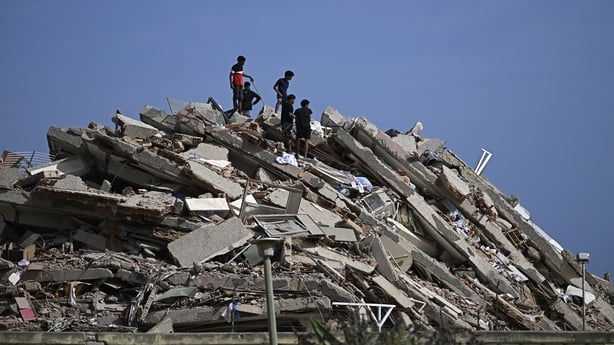 People search for survivors while others try to salvage belongings in a collapsed building