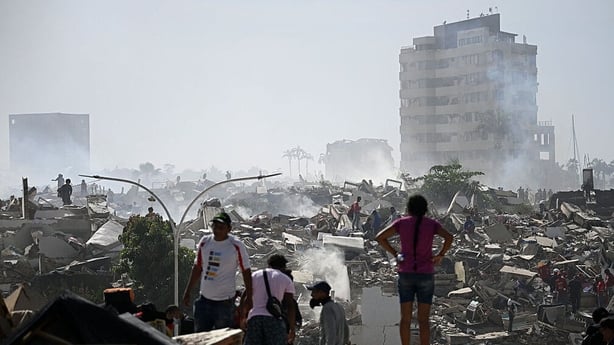 Volunteers search for possible victims in a collapsed building following twin earthquakes in Caraballeda, La Guaira state
