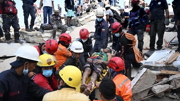 Venezuelan Civil Protection members and firefighters rescue 21-year-old Patrick Vargas from the rubble of a collapsed building in Catia La Mar, La Guaira, Venezuela, on June 26, 2026