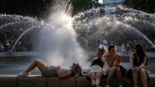 Residents of Warsaw cool off near a fountain in the city centre during the heatwave that has reached Poland