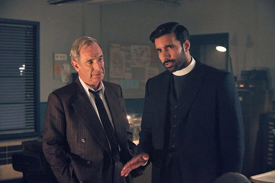 man in suit and vicar in office