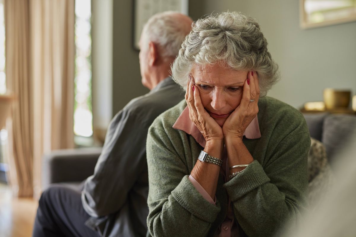 Upset senior couple sitting back to back on couch while looking away and ignore each other. Elderly couple sit separate having problems in relationship, thinking of breakup or divorce with copy space. Upset old woman after fight dispute with her husband, breaking up.