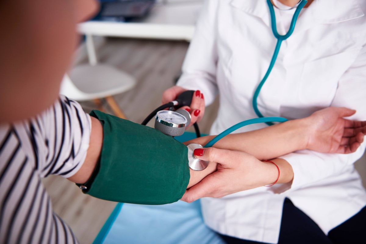 A doctor checking a patient's blood pressure